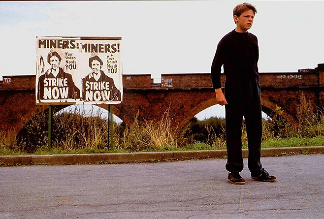 영화의 시대적 배경은 영국에서 광부 대파업이 일어난 1980년대다. 빌리가 등지고 서 있는 포스터에는 광부들에게 파업에 동참할 것을 권하는 메시지가 담겨 있다.  /사진 제공=팝엔터테인먼트