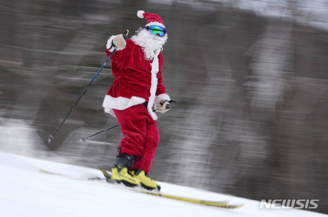 [뉴리=AP/뉴시스] 11일(현지시간) 미국 메인주 뉴리의 선데이 리버 스키 리조트에서 산타클로스 복장을 한 스키어가 스키를 타고 있다. 2022.12.12.