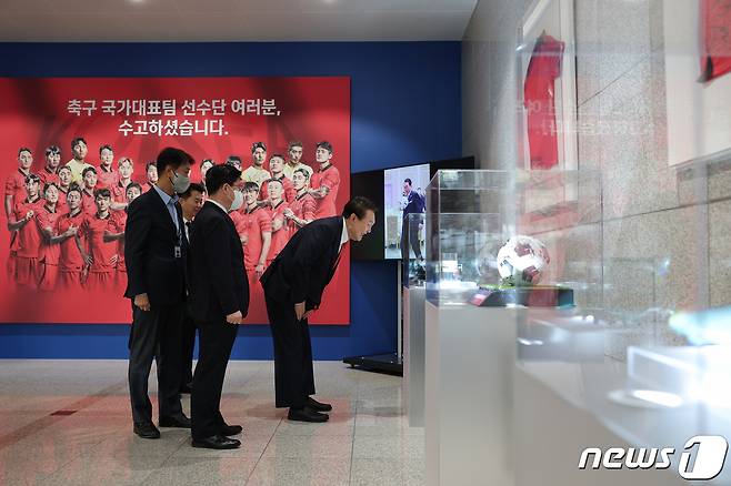 윤석열 대통령이 13일 용산 대통령실 청사 로비에 전시된 카타르 월드컵 축구 국가대표팀 기념사진 및 기념품을 살펴보고 있다.  (대통령실 제공) 2022.12.13/뉴스1 ⓒ News1 오대일 기자