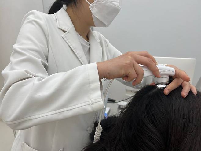 닥터포헤어 케어랩 관계자가 현미경을 활용해 두피 및 모발 상태를 진단하고 있다.ⓒ