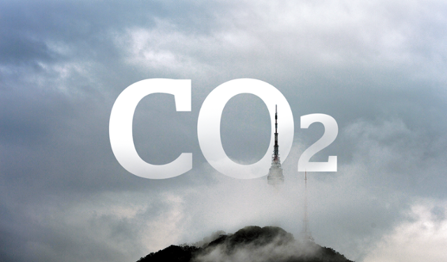 서울의 남산타워를 구름이 둘러싸고 있다. 그 위에 이산화탄소(CO₂) 문자를 합성했다. 서울은 세계 다른 대도시들에 비해 탄소감축 노력이 극히 미미하다. 그래픽=김대훈 기자