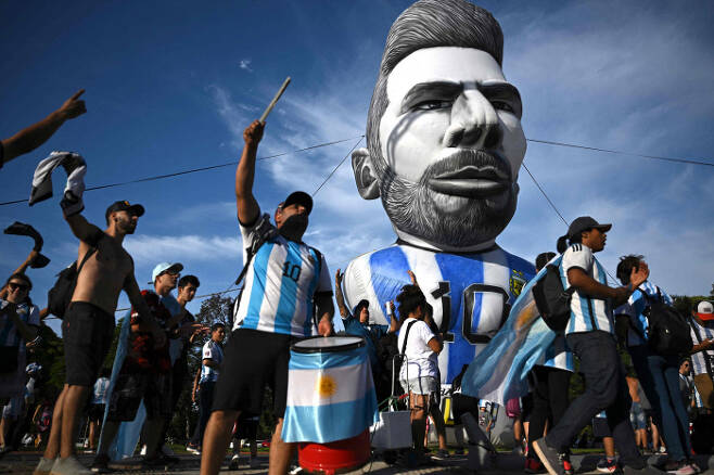 카타르 월드컵 기간 중 아르헨티나 수도 부에노스아이레스에서 많은 축구팬들이 리오넬 메시 조형물 앞에서 거리응원을 하고 있다. 부에노스아이레스 | AFP연합뉴스