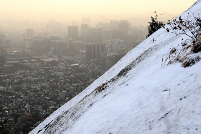 13일 오전 서울 인왕산 바위가 하얀 옷을 입고 있다. 이날 서울지역에 미세먼지 주의보가 발령돼 도심이 뿌옇게 보인다. 문호남 기자