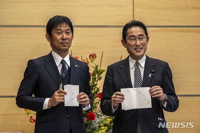 [도쿄=AP/뉴시스] 기시다 후미오(오른쪽) 일본 총리가 8일 도쿄 총리관저에서 일본 축구 대표팀의 모리야스 하지메 감독과 서로의 친필 사인을 교환한 후 기념 촬영을 하고 있다. 2022.12.08.