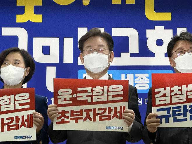 이재명 더불어민주당 당대표가 13일 대전 대덕구 유성문화원에서 열린 '찾아가는 국민보고회 대전·세종편'에 참석해 '윤·국힘은 초부자감세'라는 피켓을 들고 포즈를 취하고 있다. 뉴시스