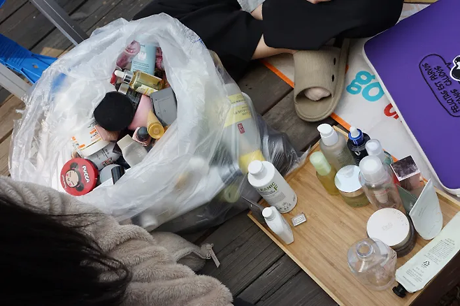 ‘화장품 어택’ 시민 모니터링 요원들이 지난해 4월 서울 성북구 녹색연합에 모여 다 쓴 화장품 용기 가운데 재활용할 수 있는 것들을 골라내고 있다. 화장품 용기 대부분이 반투명하거나 색깔이 있어 재활용이 불가능했다. 재활용 시 품질이 떨어지는 복합재질로 만든 용기가 특히 많았다. 녹색연합 제공