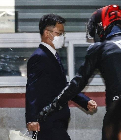 서울구치소를 나서고 있는 김만배 씨를 마중 나온 '헬멧남' 최우향 씨의 모습. [연합]