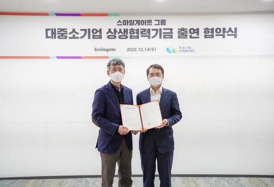 14일 경기도 성남시 판교 스마일게이트 사옥에서 성준호 스마일게이트홀딩스 대표(왼쪽)와 김영환 대·중소기업·농어업협력재단 사무총장이 상생협력기금 출연 협약을 맺고 기념 촬영을 하고 있다. 스마일게이트 제공