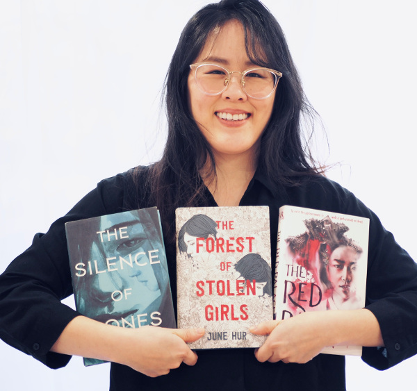 캐나다에서 거주하는 한국계 작가 허주은이 영어로 출간된 자신의 소설 세 권을 들어 보이고 있다. 왼쪽부터 첫 소설 ‘뼈의 침묵’, 이번에 국내에서 출간된 ‘사라진 소녀들의 숲’, 올해 발표한 ‘붉은 궁’이다. 허주은 작가 홈페이지