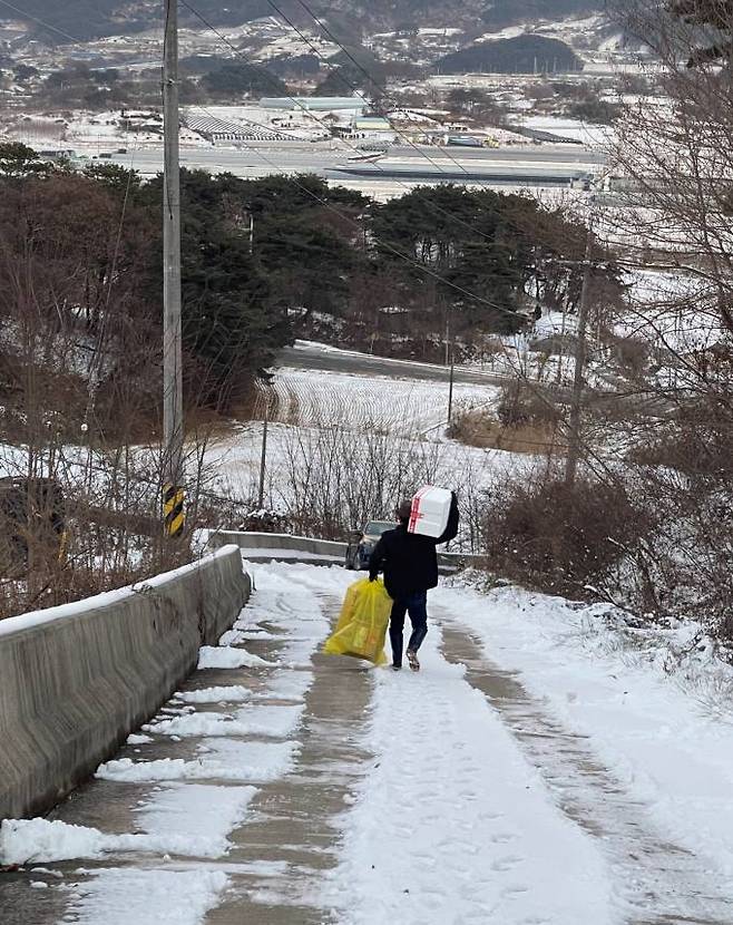 내가 뒤뚱거리며 짐 나르는 모습을 딸아이가 사진으로 담았다. 내 앞으로 멈춰 선 승용차가 보인다. 사진=임송