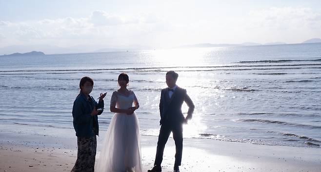 바다를 배경삼아 셀프 웨딩 사진을 찍고 있는 현지 커플의 모습ⓒ News1 윤슬빈 기자