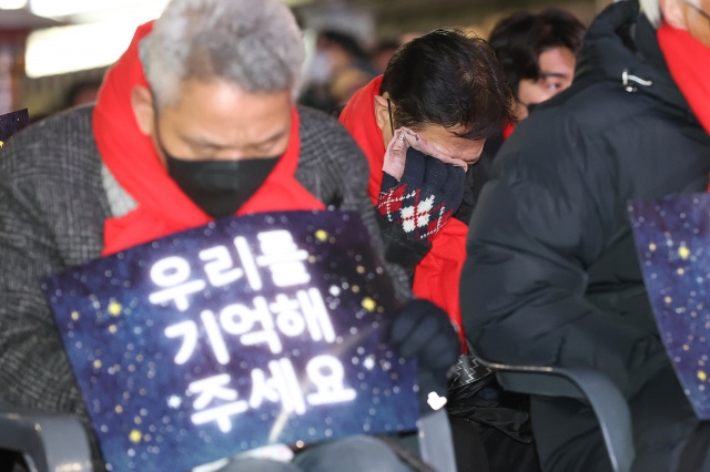 16일 오후 서울 용산구 이태원참사 사고 현장 인근에서 열린 10·29 이태원참사 유가족협의회와 10·29 이태원참사 시민대책회의 주최 참사 49일 시민추모제에서 한 유가족이 눈물을 닦고 있다. 연합뉴스