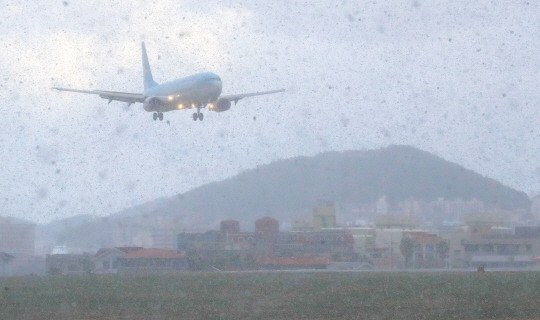 눈보라라 몰아치는 가운데 18일 오전 제주국제공항 활주로에 항공기가 착륙하고 있다. 뉴시스