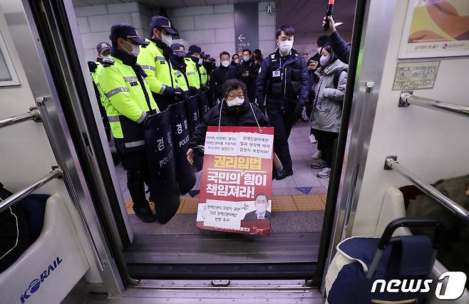 전국장애인차별철폐연대(전장연) 회원들이 19일 오전 서울 지하철1호선 서울역에서 장애인 권리 예산 확보를 위한 지하철 타기 선전전을 하고 있다. 2022.12.19/뉴스1 ⓒ News1 박세연 기자