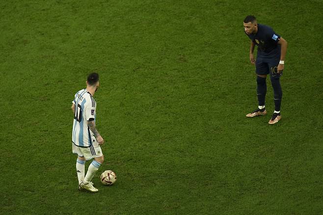 France's Kylian Mbappe, right, watches Argentina's Lionel Messi, left, during the World Cup final soccer match between Argentina and France at the Lusail Stadium in Lusail, Qatar, Sunday, Dec. 18, 2022. (AP Photo/Francisco Seco)<저작권자(c) 연합뉴스, 무단 전재-재배포 금지>