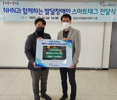 사진은 성남시 자원봉사센터 김재성 사무국장(사진 왼쪽)과 NHN 김재환 대외정책실장(사진 오른쪽)이 발달장애아동 사고 예방을 위한 스마트 태그 전달식을 마치고 기념촬영을 하고 있는 모습.