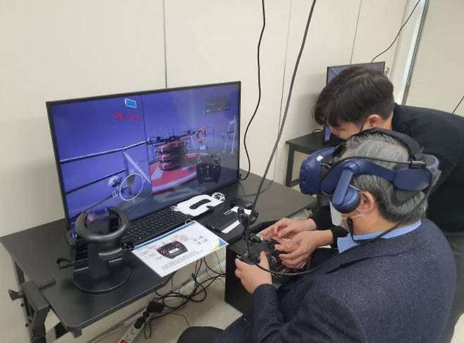 한 방문객이 VR 시뮬레이터를 통해 구조용 드론을 조종해 보는 모습