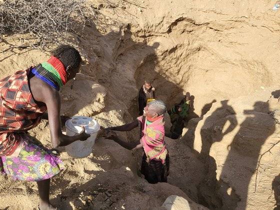 지난 6일(현지시간) 케냐 투르카나주의 로통와 마을에서 주민들이 지하 20m에서 물을 길어 오르고 있다. 지하수 관정 시스템이 없는 이곳 주민들은 땅을 파서 물을 얻고 있다. 마을 남성들은 가축들의 먹이를 찾아 먼 곳을 나가기 때문에 땅을 파서 물을 기르는 일은 여성들의 몫이다. 지하 20m에서 양동이를 통해 물을 올리기 위해서는 최소 12명의 여성이 필요하다. [외교부 공동취재단(케냐 투르카나주)]