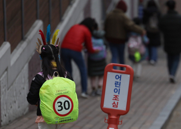 지난 13일 강남구 언북초등학교 앞에 형광색 커버가 씌워진 가방을 멘 학생이 하교하고 있는 모습. 연합뉴스