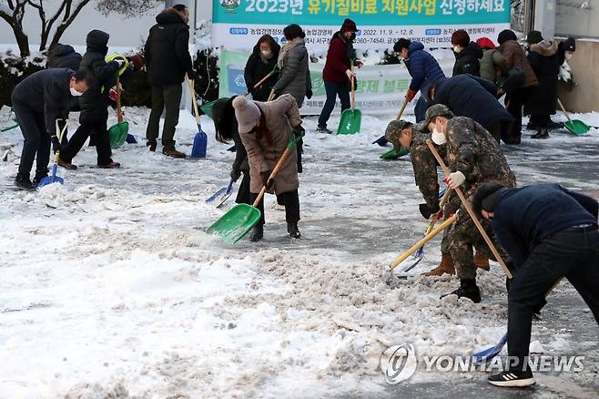 제설 작업하는 주민·공무원 (광주=연합뉴스) 정회성 기자 = 19일 오전 광주 서구 금호1동 행정복지센터 민원인 주차장에서 주민자생단체 회원, 공무원, 군인 등이 쌓인 눈을 치우고 있다. 2022.12.19 hs@yna.co.kr