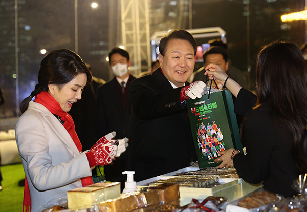 윤석열 대통령과 김건희 여사가 지난 16일 오후 서울 종로구 열린송현광장에서 열린 윈·윈터 페스티벌 개막식에서 에어돔 부스를 방문, 물건을 구입하고 있다. (사진=저작권자(c) 연합뉴스, 무단 전재-재배포 금지)