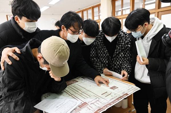 2023학년도 대학수학능력시험 성적표 배부일인 지난 9일 부산 남구 동천고등학교에서 교사와 학생들이 대입 배치표를 살펴보고 있다.  여주연 기자