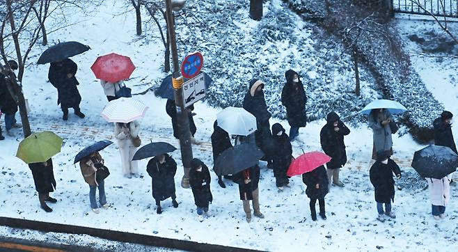 수도권 지역에 대설주의보가 내려진 21일 오전 경기도 수원시 영통구 망포역 인근 버스정류장에서 출근길 시민들이 버스를 기다리고 있다. /뉴시스