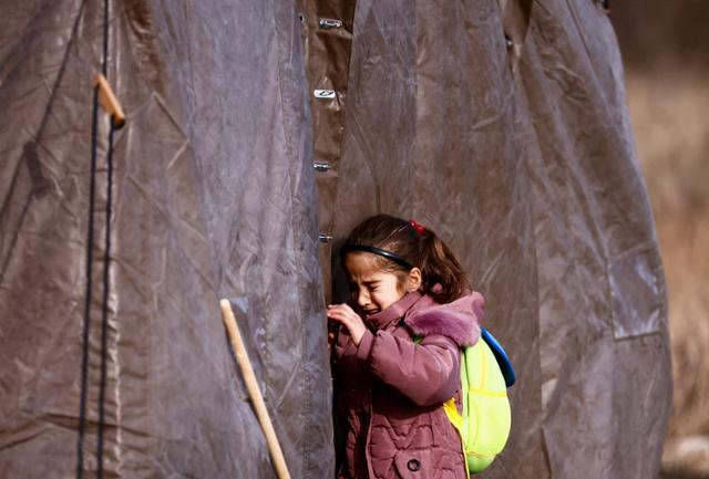 지난 3월 1일(현지시간) 러시아군의 침공을 피해 폴란드 남동부 프셰미실로 피란 온 한 우크라이나 어린이가 임시 수용소로 쓰이는 텐트 밖에 서서 울음을 터뜨리고 있다. 프셰미실=로이터 연합뉴스