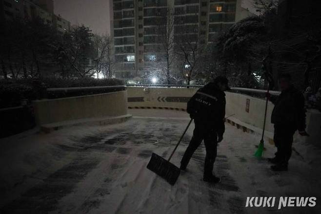 수도권과 중부지방에 대설특보가 발효된 21일 오전 경기 고양시 시내 한 아파트 경비원들이 주차장 언덕을 못올라오는 차량을 위해 제설작업을 하고 있다.