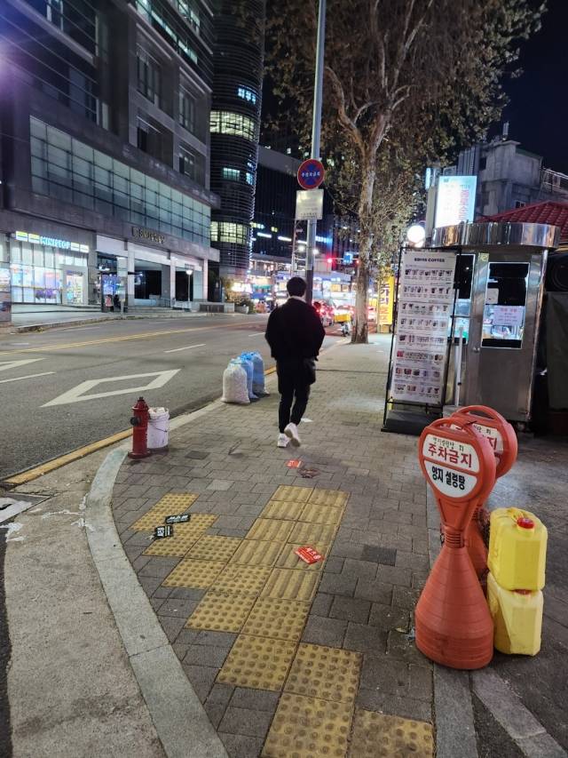 지난 16일 서울 마포구 마포역 인근에서 한 남성이 외투 주머니 속에서 꺼낸 '셔츠룸 전단'을 뿌리고 있다.