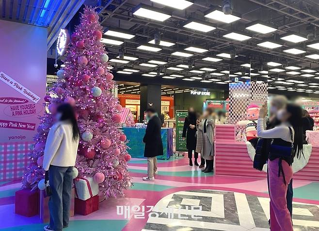 20일 서울 여의도 더현대서울 지하 2층 야놀자 ‘핑크홀리데이’ 팝업 스토어에서 방문객들이 인증샷을 찍고 있다. [이하린 기자]