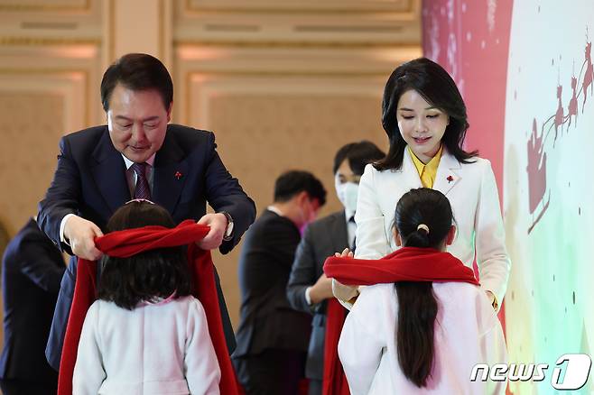 윤석열 대통령과 김건희 여사가 23일 오후 청와대 영빈관에서 열린 보호아동·자립준비 청년과 함께하는 크리스마스 행사에서 아이들에게 빨간 목도리를 선물하고 있다. (대통령실 제공) 2022.12.23/뉴스1 ⓒ News1 오대일 기자