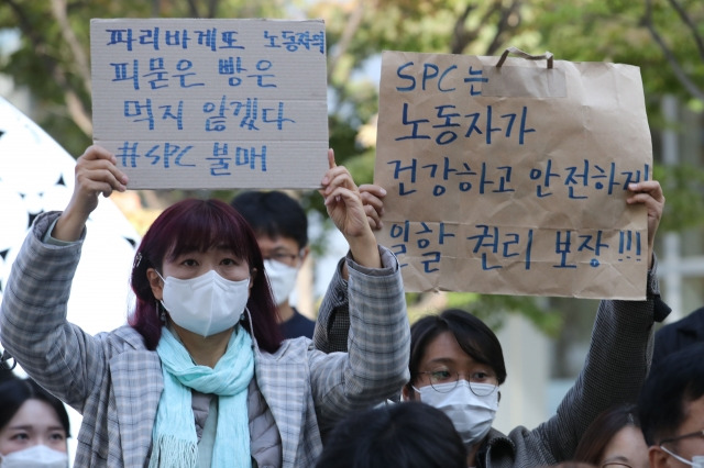 지난 10월 20일 오후 서울 양재동 SPC 본사 앞에서 열린 SPC 계열사 SPL 평택 제빵공장 사망 사고 희생자 서울 추모행사에 참여한 시민이 SPC를 규탄하는 손피켓을 들고 있다. 뉴시스