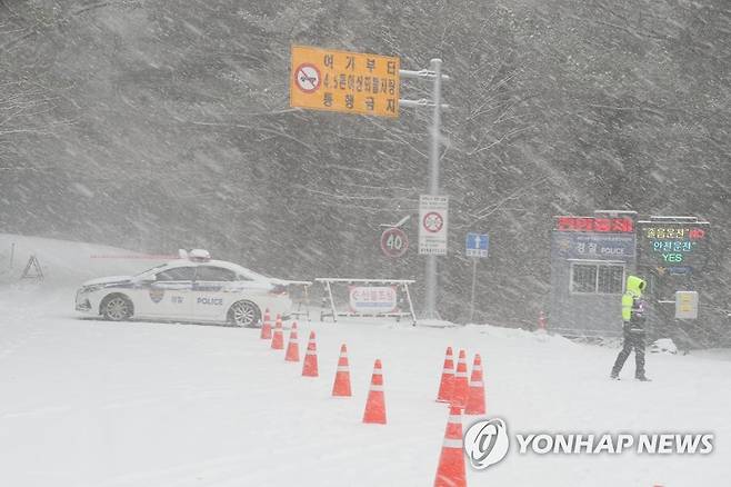 제주 1100도로 운행 전면 통제 (제주=연합뉴스) 박지호 기자 = 제주도 산간에 대설경보가 내려진 22일 오전 제주시 어승생 1100도로 입구에서 경찰이 차량을 전면 통제하고 있다. 2022.12.22 jihopark@yna.co.kr