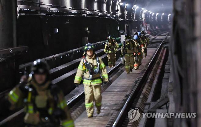 선로에서 철수하는 소방대원들 (서울=연합뉴스) 김도훈 기자 = 서울지하철 3호선 무악재역∼독립문역 사이 터널 내 선로에서 화재가 발생한 23일 오전 서울 종로구 지하철3호선 독립문역에서 화재진압을 마친 소방대원들이 선로에서 철수하고 있다. 2022.12.23 superdoo82@yna.co.kr