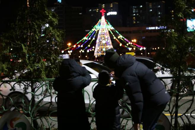 시민들이 걸음을 멈추고 경남 창원시청 앞 광장에 세워진 성탄 트리를 촬영하고 있다. / 이세령 기자 ryeong@