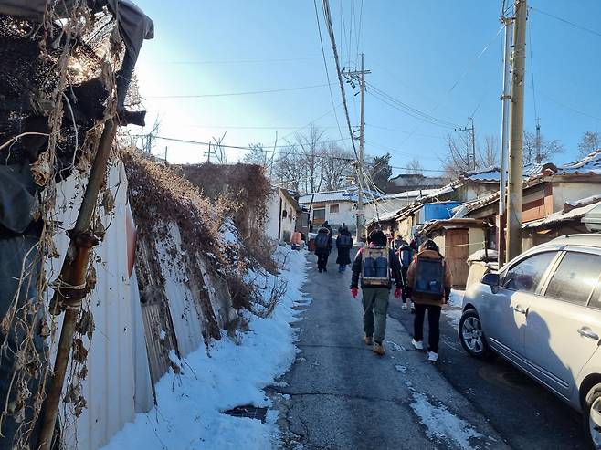 24일 오전 서울 노원구 백사마을에서 연탄 배달에 나선 봉사자들이 언덕을 오르고 있다./강우량 기자