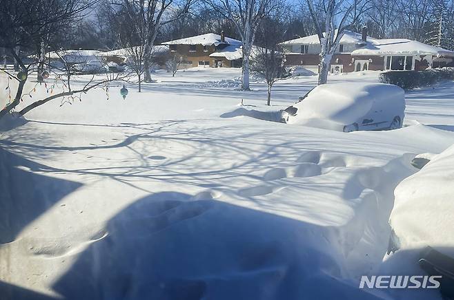 [애머스트=AP/뉴시스] 25일(현지시간) 미 뉴욕주 이리 카운티의 애머스트 마을의 자동차가 눈에 파묻혀 있다. 미국 전역에 불어닥친 북극 눈 폭풍이 일주일째 이어져 혹한과 폭설로 지금까지 최소 28명이 목숨을 잃은 것으로 나타났다. 2022.12.26.