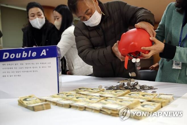 전북 전주시 완산구 노송동 ‘얼굴 없는 천사’가 올해도 어김없이 성금을 놓고 사라졌다. 천사가 성금을 두고 간 27일, 노송동주민센터에서 직원들이 성금을 세고 있다. [사진출처=연합뉴스]