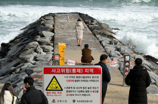 26일 일부 관광객들이 너울성 파도로 풍랑특보가 발효되면서 출입이 금지된 유명 드라마 촬영지 강원 강릉시 주문진 방사제에서 다소 위험한 기념사진을 찍고 있다. 강릉=연합뉴스