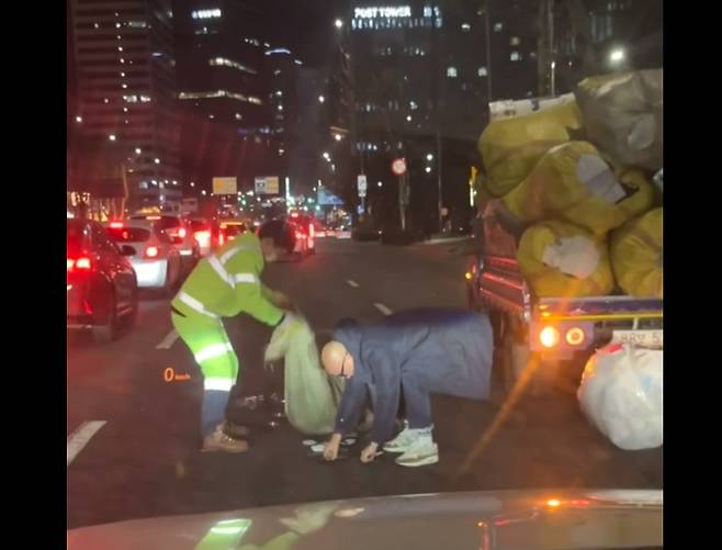 지난 26일 서울 마포구 공덕역 인근에서 방송인 홍석천씨가 미화원을 도와 쓰레기를 줍고 있다./ 보배드림