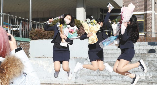 28일 인천 계양구 계산여고에서 졸업생들이 기념사진을 찍기 위해 꽃다발을 든 채 힘차게 뛰어오르고 있다. 고교시절을 신종 
코로나바이러스 감염증(코로나19)과 함께 보내며 입학식 수업 등을 상당 부분 비대면으로 진행했던 학생들은 “친구들 얼굴을 보면서 
졸업할 수 있어서 그나마 다행”이라고 입을 모았다. 사회적 거리 두기가 해제되면서 상당수 초중고교에서 3년 만에 대면 졸업식이 
부활하는 모습이다. 인천=전영한 기자 scoopjyh@donga.com