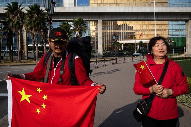 2019년 12월 마카오를 방문한 중국인 방문객들이 중국 국기를 들고 시진핑 중국 국가주석의 자동차 퍼레이드를 기다리고 있다./AFPBBNews=뉴스1