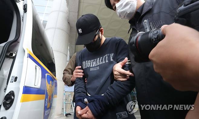 검찰 송치되는 21년 전 대전 은행 강도 피의자 (대전=연합뉴스) 양영석 기자 = 대전 둔산경찰서 관계자들이 21년 만에 붙잡힌 대전 국민은행 권총 강도살인 피의자 이정학(51)을 검찰로 송치하고 있다. 2022.9.2 youngs@yna.co.kr