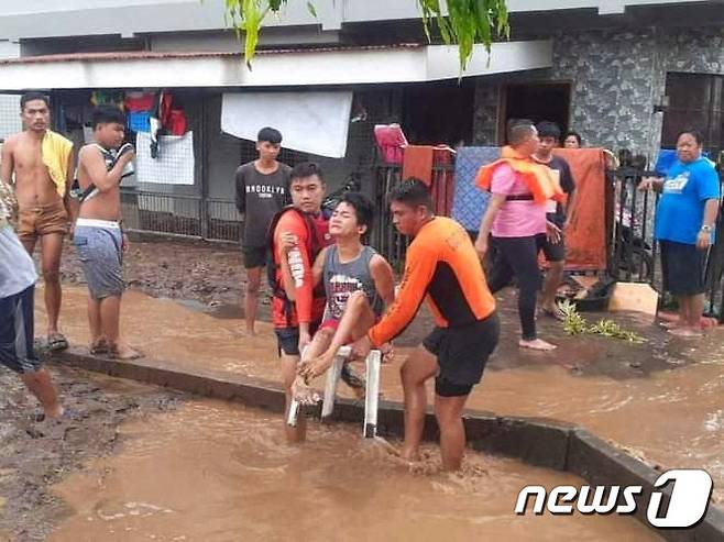 26일(현지시간) 필리핀 미사미스 옥시덴탈주(州) 프라리델에서 구조대원들이 홍수 피해를 입은 주민을 구조하고 있다. ⓒ 로이터=뉴스1 ⓒ News1 권진영 기자