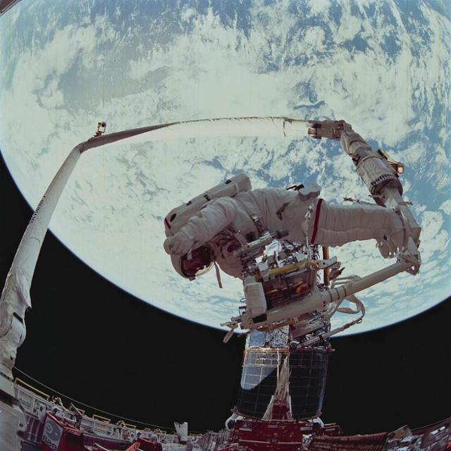 우주비행사 스토리 머스그레이브가 1993년 12월 우주왕복선의 캐나담을 이용해 허블 우주망원경을 수리하고 있다. 나사 제공
