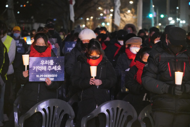 ▲30일 '10.29 이태원 참사 2차 시민추모제'에서 희생자 유가족들이 촛불을 들고 묵념하고 있다. ⓒ프레시안(한예섭)