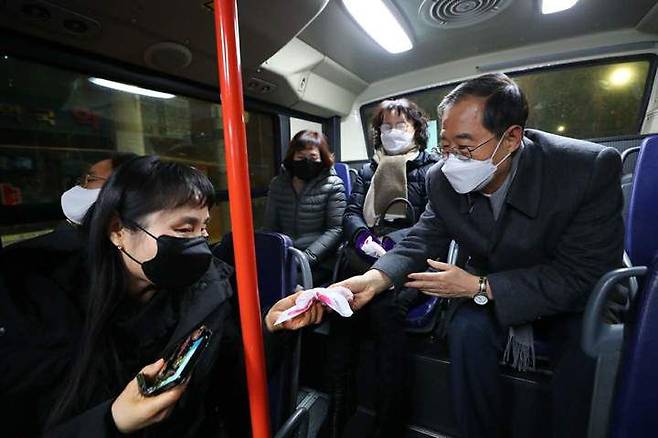 한덕수 총리가 2일 오전 4시 146번 버스에 탑승해 탑승객들에게 핫팩을 나눠주고 있다. /뉴시스