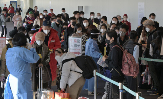 2일 인천국제공항 제1여객터미널 입국장에서 공항 관계자들이 중국발 입국자를 분류하고 있다. 방역당국은 이날부터 중국에서 항공편이나 배편으로 입국하는 모든 사람에 대해 코로나19 유전자증폭(PCR) 검사를 실시하는 등 고강도 방역 대책을 시작했다. [사진공동취재단, 영종도=연합뉴스]