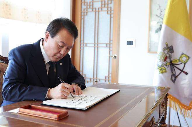 [서울=뉴시스] 윤석열 대통령이 2일 서울 종로구 주한 교황청대사관에 마련된 고 베네딕토 16세 명예교황의 분향소를 찾아 조문, 방명록을 작성하고 있다. (사진=대통령실 제공) 2023.01.02. photo@newsis.com *재판매 및 DB 금지